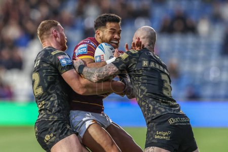 Photo for Esan Marsters tackled by Jack Hughes of Leigh Leopards and Zak Hardaker of Leigh Leopards during the Betfred Super League Round 12 match Huddersfield Giants vs Leigh Leopards at John Smith's Stadium, Huddersfield, United Kingdom, 24th May 2024 - Royalty Free Image