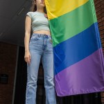 Beautiful young girl with lgbt flag, lesbian with flag at gay parade, ally or gay supporting equality in love outdoors
