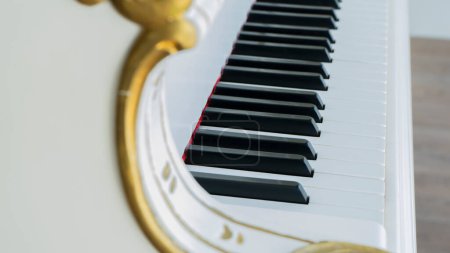 Téléchargez les photos : View of a white and gold piano - en image libre de droit