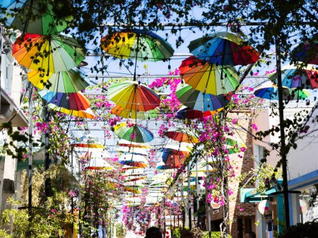 Paraguas de arco iris cuelgan por encima de las cabezas en el centro de la ciudad en América del Sur