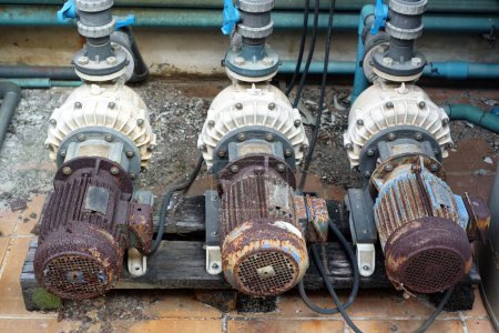 Téléchargez les photos : A damage and very rusty three motor pump systems because bad weather is out building. - en image libre de droit