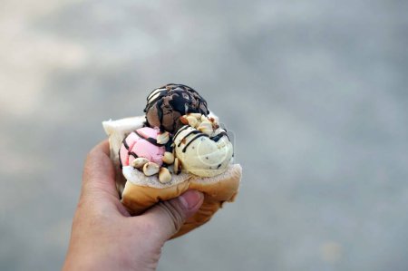 Téléchargez les photos : A hand was holding an ice cream after bought. - en image libre de droit
