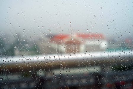 Téléchargez les photos : La pluie tombe sur la fenêtre de la ville, voir l'ombre d'une école. - en image libre de droit