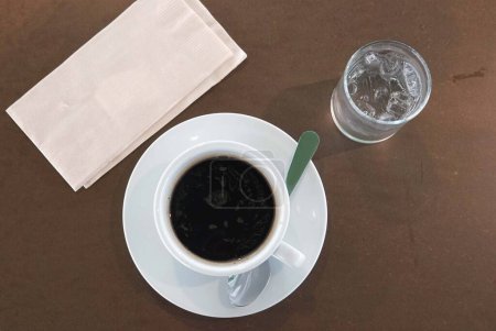 Téléchargez les photos : Un veiw supérieur d'une tasse à café et un verre d'eau sur une table brune, photo de stock - en image libre de droit