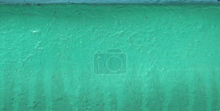 Téléchargez les photos : Un mur de ciment vert vintage enduit de colle pour les milieux et la texture, Fond abstrait - en image libre de droit