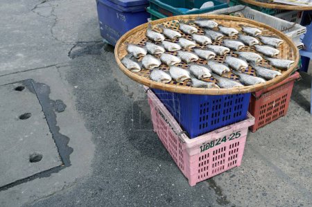Téléchargez les photos : Un poisson séché dans un panier à côté de la rue près du marché du bazar. - en image libre de droit