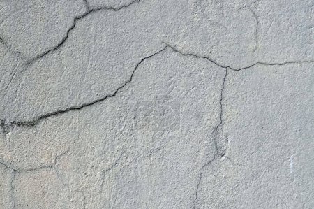 Téléchargez les photos : Une texture fissurée de vieux mur rustique recouvert de plâtre stuc gris fond abstrait et texture pour la conception. - en image libre de droit