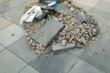 Téléchargez les photos : Un déchet plastique sur un chantier de construction déchire en enlevant les vieilles tuiles du trottoir, la pollution de l'environnement. - en image libre de droit