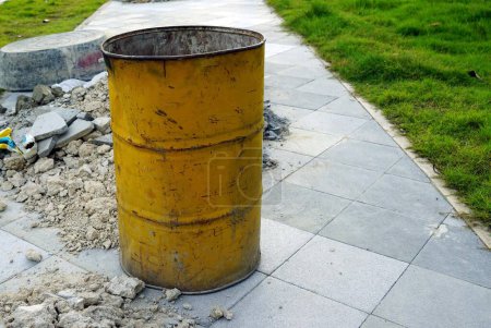 Téléchargez les photos : Ancien tonneau jaune rouillé au sol sur le chantier de construction. - en image libre de droit