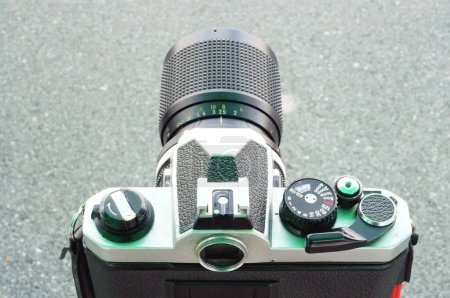 Photo for Close up a back side  veiw of a vintage film camera with black lens on road surface background - Royalty Free Image