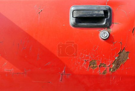 Téléchargez les photos : Un corps de porte vieille voiture rouge fissurée, fond grunge abstrait pour la conception. - en image libre de droit