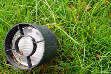 Téléchargez les photos : Fermer une vieille lampe noire sur herbe verte dans le jardin. - en image libre de droit