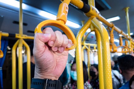 Close-up of hands holding handrails in public transport, risk germs transmission and infections