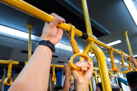 Foto de Primer plano de las manos que sostienen pasamanos en el transporte público, transmisión de gérmenes de riesgo e infecciones - Imagen libre de derechos