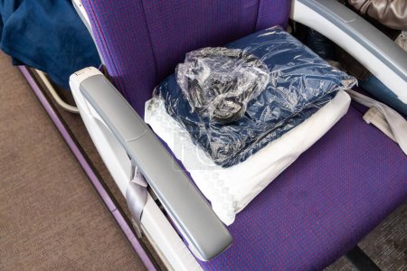 Sanifizierte und versiegelte Wolldecke in Plastiktüte, die den Passagieren zur Verfügung gestellt wird, um sich während des Langstreckenfluges warm und bequem zu halten