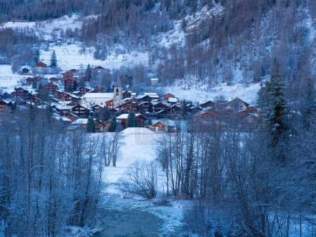 Photo for Early morning view through the valley, towards Evolene in Val dHerens, Switzerland, a beautiful and famous historic village surrounded by winter landscape. - Royalty Free Image
