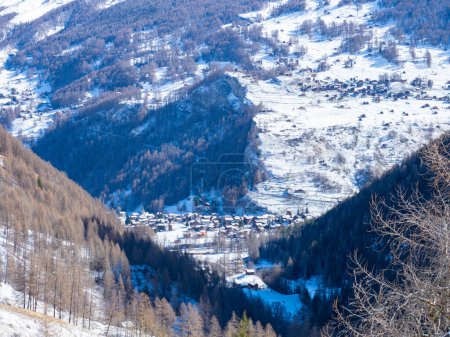Foto de Vista de día hacia Les Hauderes en Val dHerens, Suiza, un hermoso y famoso pueblo histórico rodeado de bosques y picos en el paisaje invernal - Imagen libre de derechos