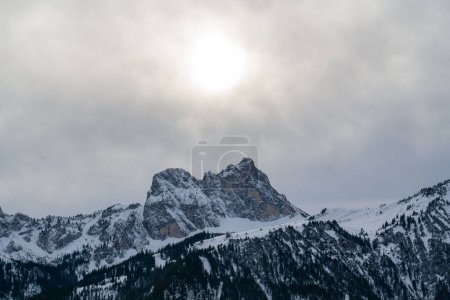 Photo for The peak of Aggenstein in the Bavarian Alps, Germany, is a famous destination for hikers. Situation of the mountain during winter conditions, the sun is shining through the clouds. - Royalty Free Image