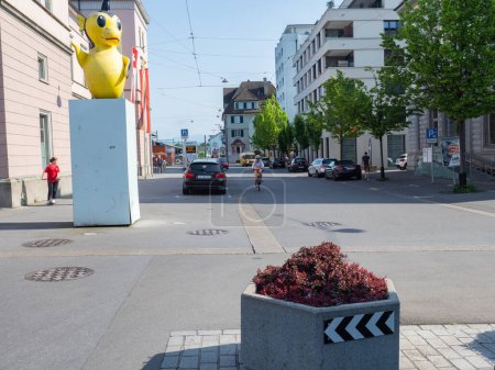 Téléchargez les photos : Réaménagement de l'espace public à Romanshorn, en Suisse : zones de circulation calme avec des arbres et des pots de fleurs devant la gare - en image libre de droit