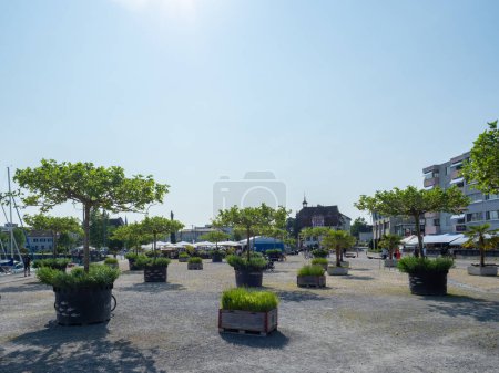 Photo for The city of Romanshorn, Switzerland, is directly situated at lake Constance. Situation of the big concrete plaza with plant troughs in the former harbour industrial area in front of the city. - Royalty Free Image