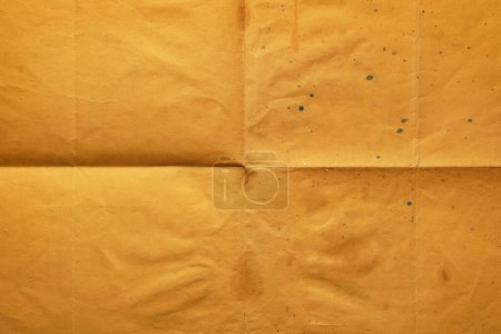 Photo for Close-up of old orange notepaper folded in four, texture background - Royalty Free Image
