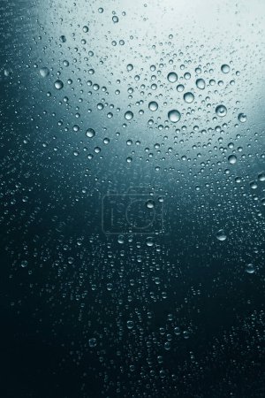 Foto de Burbujas de agua sobre una superficie sombreada, fondo azul - Imagen libre de derechos
