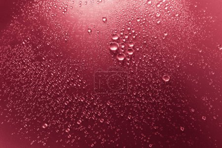 Téléchargez les photos : Bulles d'eau sur une surface ombragée, fond rouge - en image libre de droit