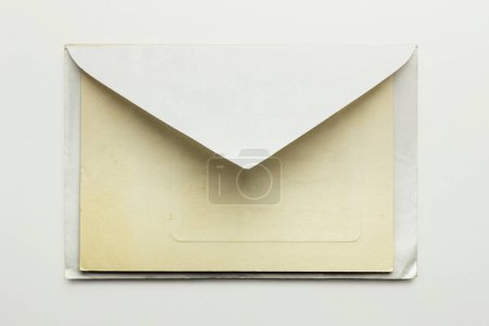 Téléchargez les photos : Ancienne enveloppe avec carte postale, isolée sur fond blanc - en image libre de droit
