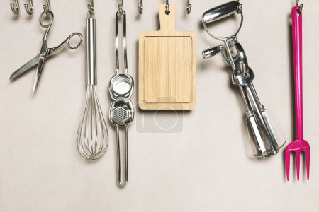 Photo for Kitchen interior, utensils for cooking hanging with hooks on the wall - Royalty Free Image