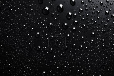 Foto de Gotas de agua sobre una superficie negra, fondo abstracto - Imagen libre de derechos