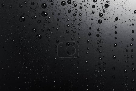 Téléchargez les photos : Gouttes d'eau sur une surface noire, fond abstrait - en image libre de droit