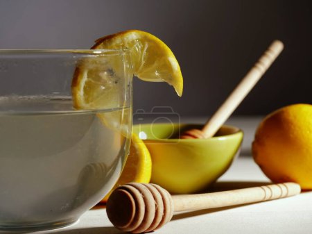 Photo for Making hot Lemon and honey for natural treatment of cold and flu medium shot selective focus - Royalty Free Image