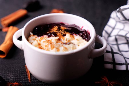 Photo for Typical Peruvian dessert: rice pudding and purple mazamorra on a dark background. - Royalty Free Image