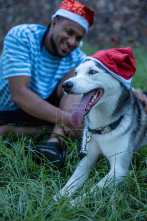 Photo for Man with his pet wearing Christmas caps. - Royalty Free Image