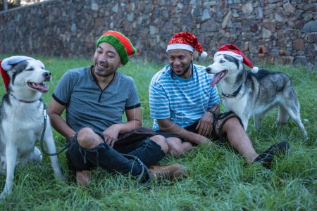 Photo for Friends with Christmas hats with their dogs. - Royalty Free Image