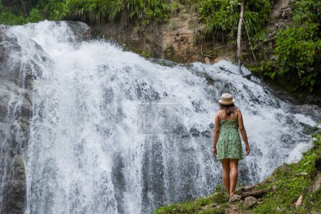 Woman traveler contemplates a waterfall in the Peruvian jungle.