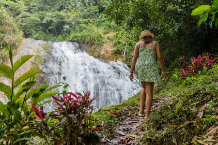 Photo for Tourist woman walks towards a waterfall, in the Peruvian jungle. - Royalty Free Image
