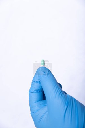Photo for Hand with a blue latex glove, clutching a tablet. - Royalty Free Image