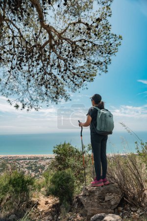 Hiker rests in the mountains and enjoys the views on the Mediterranean coast.