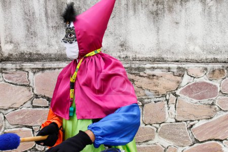 Téléchargez les photos : Minas Gerais, Brazil - March 4, 2019: masqueraders known as cainaguas wearing their characteristic colorful clothes on the streets during carnival in the interior of Minas Gerais - en image libre de droit