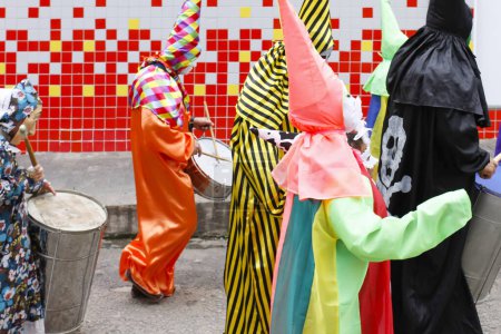 Téléchargez les photos : Minas Gerais, Brazil - March 4, 2019: masqueraders known as cainaguas wearing their characteristic colorful clothes on the streets during carnival in the interior of Minas Gerais - en image libre de droit