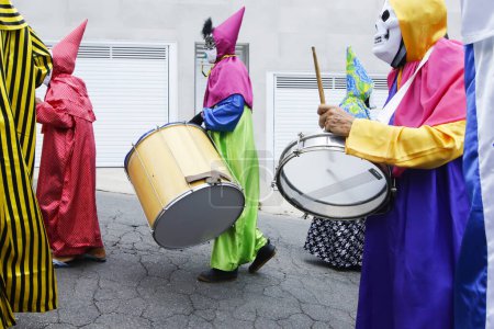 Téléchargez les photos : Minas Gerais, Brazil - March 4, 2019: masked people known as cainaguas wearing their characteristic colorful clothes on the streets during carnival in the interior of Minas Gerais - en image libre de droit