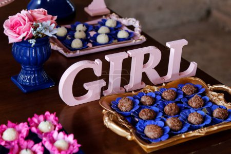 Téléchargez les photos : Grandes lettres roses GIRL et bonbons sur la table à la révélation thé partie - bébé sexe révéler concept de fête - en image libre de droit