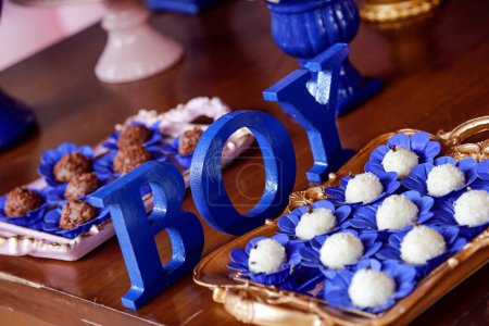 Téléchargez les photos : Grandes lettres bleues Garçon et bonbons sur la table à la révélation thé partie - bébé sexe révéler concept de fête - en image libre de droit