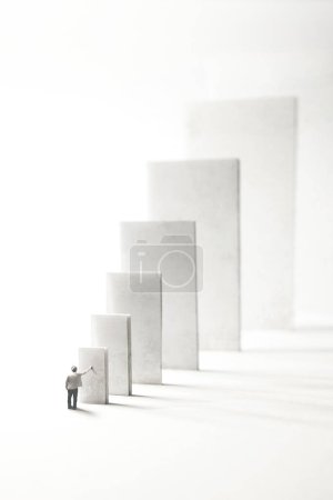 Photo for Man actuates domino effect, surreal concept - Royalty Free Image