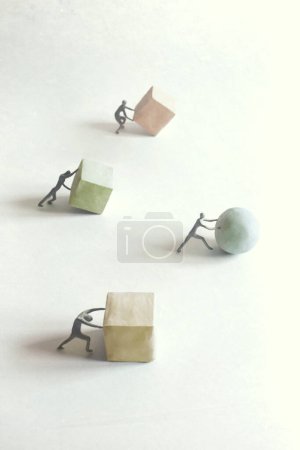 Foto de Hombres empujando bloques de forma geométrica, concepto surrealista - Imagen libre de derechos