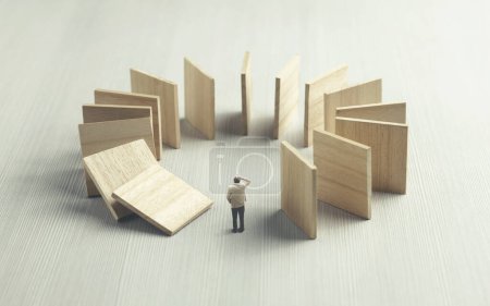 Photo for Worried man observing domino collapsing on him, surreal concept - Royalty Free Image