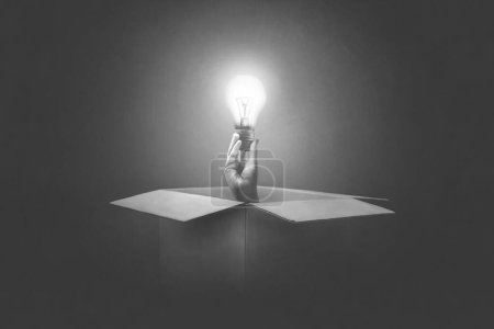 Téléchargez les photos : Illustration d'une ampoule à main sortant d'une boîte en papier, concept surréaliste - en image libre de droit