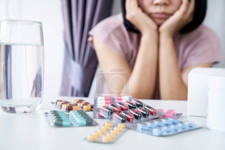 Téléchargez les photos : Femme asiatique ennuyée de prendre plusieurs paquets de médicaments Médicament à long terme pour une maladie chronique - en image libre de droit