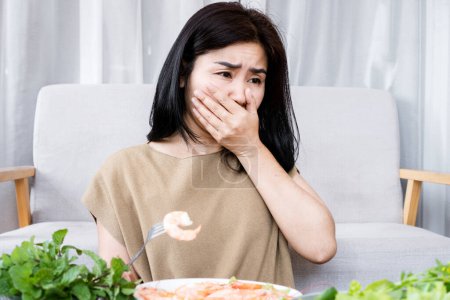 Foto de Mujer asiática que experimenta náuseas y vómitos debido a la alergia al camarón - Imagen libre de derechos